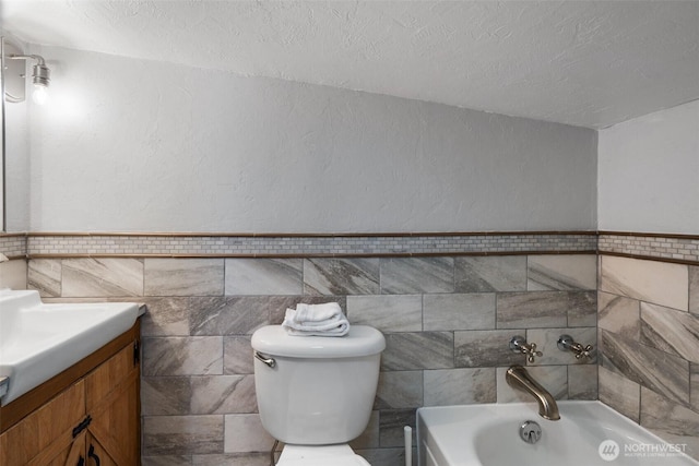 2526 19th St, Bremerton, WA 98312 - full bathroom with tile walls, a bath, vanity, a textured ceiling, and toilet
