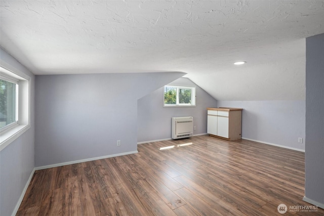 2526 19th St, Bremerton, WA 98312 - additional living space with heating unit, wood finished floors, lofted ceiling, baseboards, and a textured ceiling