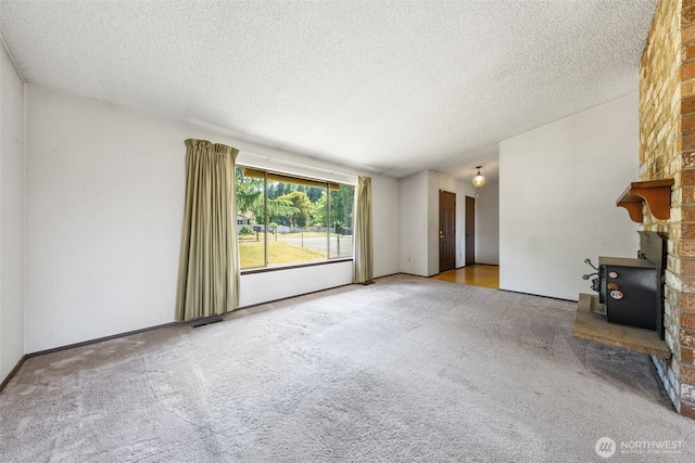 1015 143rd St S, Tacoma, WA 98444 - unfurnished living room with carpet, a wood stove, and a textured ceiling