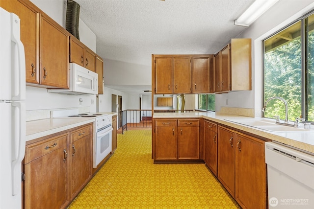 1015 143rd St S, Tacoma, WA 98444 - kitchen featuring white appliances, a sink, light flooring, light countertops, and a textured ceiling
