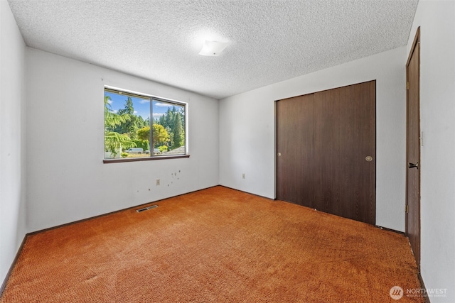 1015 143rd St S, Tacoma, WA 98444 - unfurnished bedroom featuring a closet, a textured ceiling, and carpet
