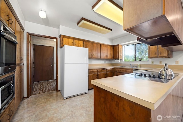1119 Sunset Ave, Bellingham, WA 98226 - kitchen with freestanding refrigerator, brown cabinets, a peninsula, and a sink
