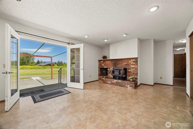 1119 Sunset Ave, Bellingham, WA 98226 - unfurnished living room featuring a textured ceiling, a wood stove, recessed lighting, and french doors