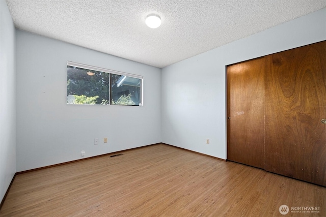 1119 Sunset Ave, Bellingham, WA 98226 - unfurnished bedroom featuring wood finished floors, a closet, a textured ceiling, and baseboards