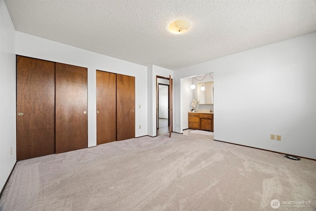 1119 Sunset Ave, Bellingham, WA 98226 - unfurnished bedroom with two closets, a textured ceiling, carpet, baseboards, and ensuite bath
