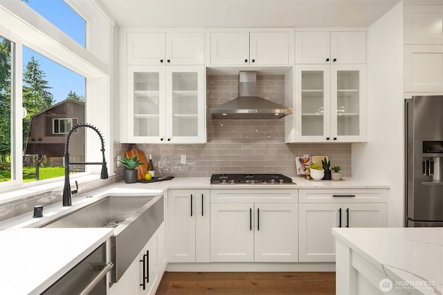 19722 Filbert Dr Unit A-3, Bothell, WA 98012 - kitchen featuring appliances with stainless steel finishes, wall chimney range hood, a sink, tasteful backsplash, and white cabinetry