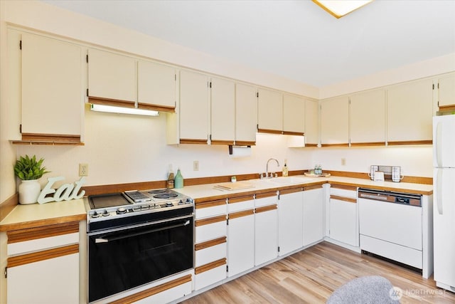 8225 212th St SW # 302, Edmonds, WA 98026 - kitchen featuring white appliances, light wood-style flooring, a sink, and light countertops