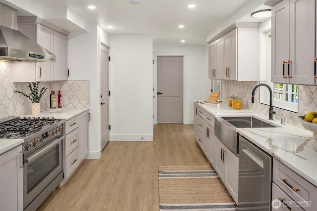 6202 122nd Ave SE, Bellevue, WA 98006 - kitchen with wall chimney range hood, appliances with stainless steel finishes, light wood finished floors, decorative backsplash, and recessed lighting