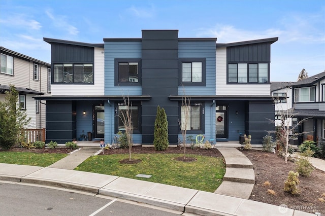 26627 NE Boyd Way Unit 101, Duvall, WA 98019 - view of front facade featuring board and batten siding, a front yard, and covered porch