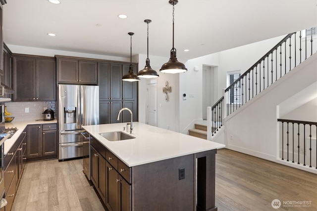 26627 NE Boyd Way Unit 101, Duvall, WA 98019 - kitchen featuring a sink, appliances with stainless steel finishes, light wood-style floors, dark brown cabinets, and recessed lighting