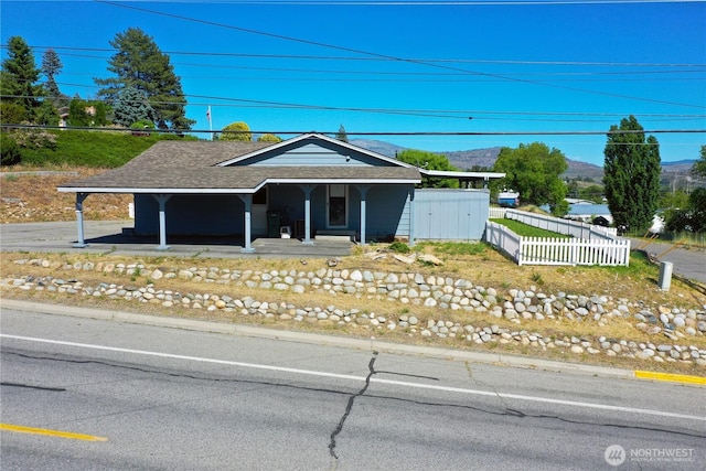 504 Ash St N, Omak, WA 98841 - single story home featuring a porch, a shingled roof, and a mountain view