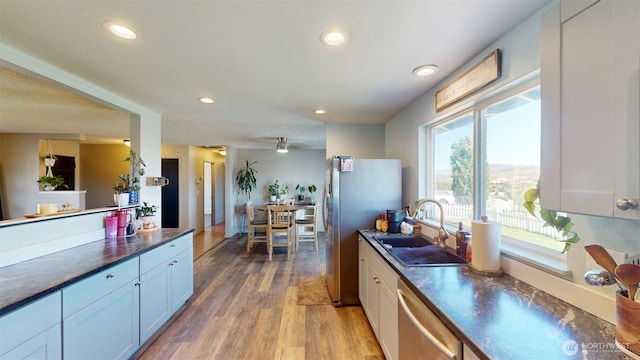 504 Ash St N, Omak, WA 98841 - kitchen with appliances with stainless steel finishes, a sink, dark countertops, light wood-type flooring, and recessed lighting