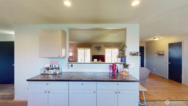 504 Ash St N, Omak, WA 98841 - kitchen with light wood-style floors, white cabinetry, a textured ceiling, and recessed lighting