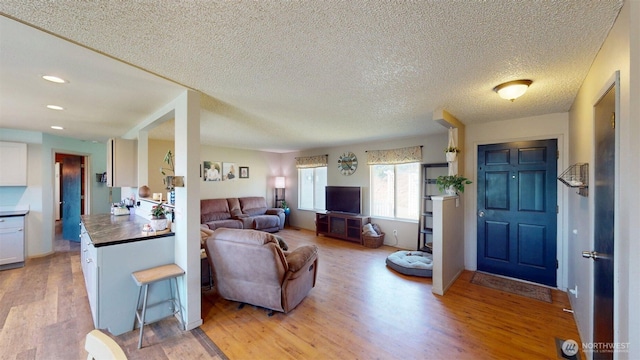 504 Ash St N, Omak, WA 98841 - living area with light wood-type flooring, a textured ceiling, and recessed lighting