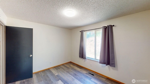 504 Ash St N, Omak, WA 98841 - unfurnished room featuring wood finished floors, a textured ceiling, and baseboards