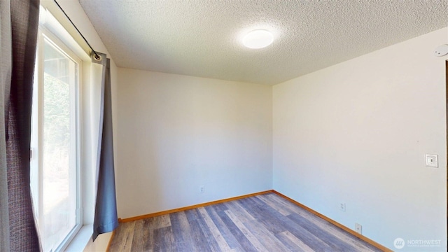 504 Ash St N, Omak, WA 98841 - empty room featuring a textured ceiling, wood finished floors, and baseboards