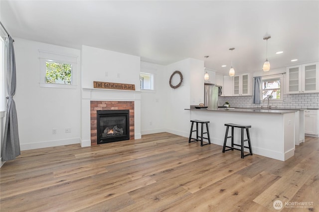 2730-2734 Nevada St, Bellingham, WA 98226 - kitchen featuring stainless steel appliances, a sink, a breakfast bar, backsplash, and white cabinets