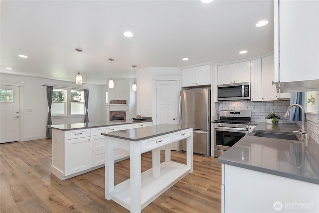 2730-2734 Nevada St, Bellingham, WA 98226 - kitchen featuring stainless steel appliances, a sink, tasteful backsplash, dark countertops, and white cabinetry