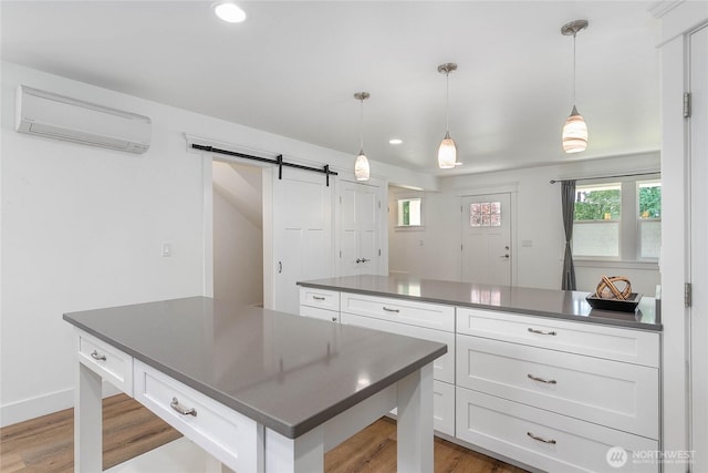 2730-2734 Nevada St, Bellingham, WA 98226 - kitchen with an AC wall unit, dark countertops, a barn door, white cabinets, and recessed lighting