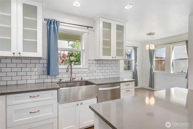 2730-2734 Nevada St, Bellingham, WA 98226 - kitchen featuring dishwasher, a sink, dark countertops, white cabinetry, and tasteful backsplash