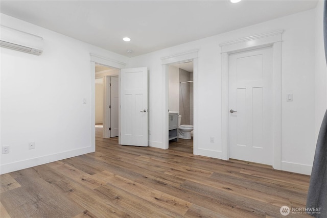 2730-2734 Nevada St, Bellingham, WA 98226 - unfurnished bedroom with an AC wall unit, baseboards, wood finished floors, recessed lighting, and ensuite bathroom