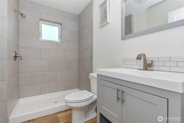 2730-2734 Nevada St, Bellingham, WA 98226 - full bathroom featuring toilet, vanity, tiled shower, decorative backsplash, and wood finished floors