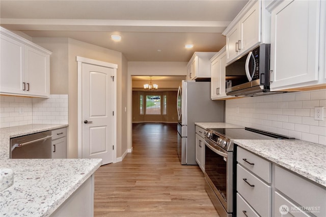 31823 44th Ave S, Auburn, WA 98001 - kitchen featuring appliances with stainless steel finishes, a chandelier, light wood-style flooring, white cabinetry, and light stone countertops