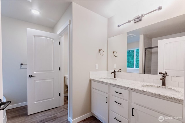 31823 44th Ave S, Auburn, WA 98001 - bathroom featuring toilet, double vanity, wood finished floors, a shower stall, and baseboards
