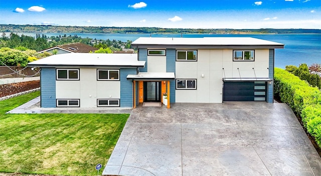 5942 Beverly Ave NE, Tacoma, WA 98422 - contemporary home featuring concrete driveway, a garage, a front lawn, and a water view