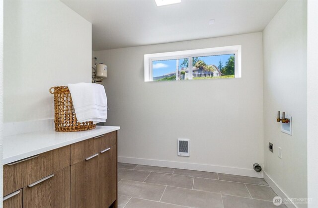 5942 Beverly Ave NE, Tacoma, WA 98422 - washroom with hookup for an electric dryer, cabinet space, baseboards, and light tile patterned floors