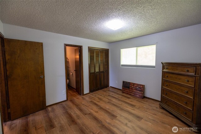 371 Pigeon Springs Rd, Onalaska, WA 98570 - bedroom featuring wood finished floors, a textured ceiling, and a closet