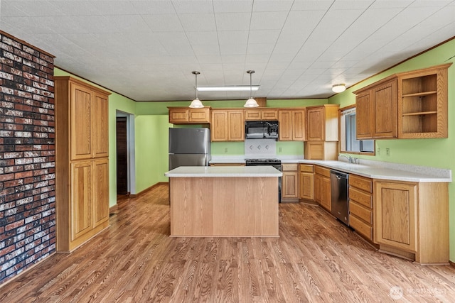 1086 W State Route 4, Skamokawa, WA 98647 - kitchen with black appliances, light wood-style flooring, light countertops, a kitchen island, and brick wall