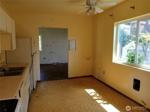 6002 S Mason Ave, Tacoma, WA 98409 - kitchen with plenty of natural light, a sink, ceiling fan, and white cabinetry