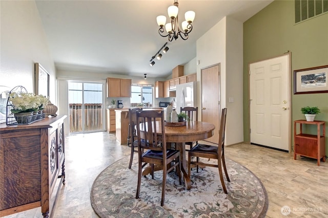19226 12th Avenue Ct E, Spanaway, WA 98387 - dining room with vaulted ceiling, a chandelier, and rail lighting
