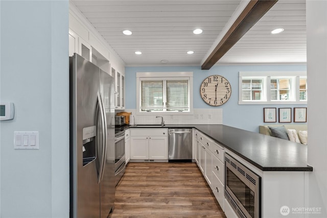 33 N Glen Ln, Pacific Beach, WA 98571 - kitchen featuring appliances with stainless steel finishes, dark countertops, a peninsula, recessed lighting, and white cabinetry