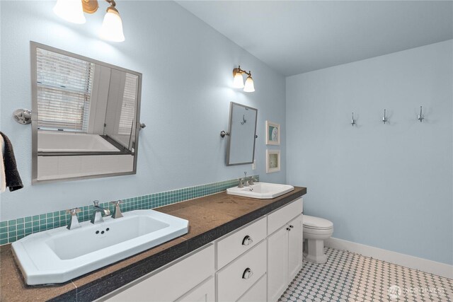 33 N Glen Ln, Pacific Beach, WA 98571 - bathroom featuring double vanity, toilet, tile patterned floors, and baseboards