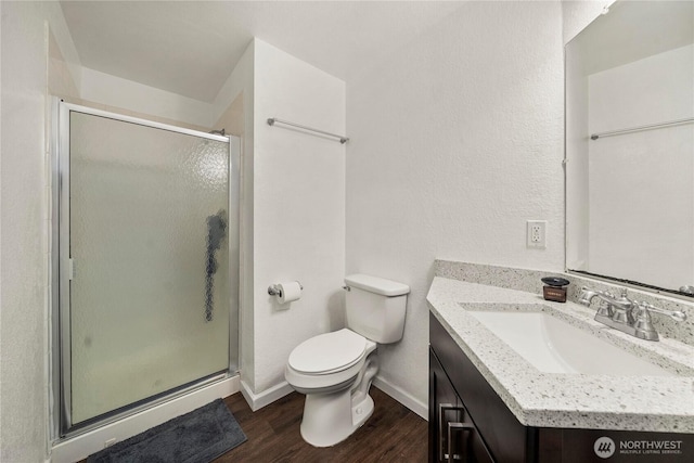 23410 18th Ave S Unit A102, Des Moines, WA 98198 - bathroom with vanity, wood finished floors, a shower stall, baseboards, and toilet