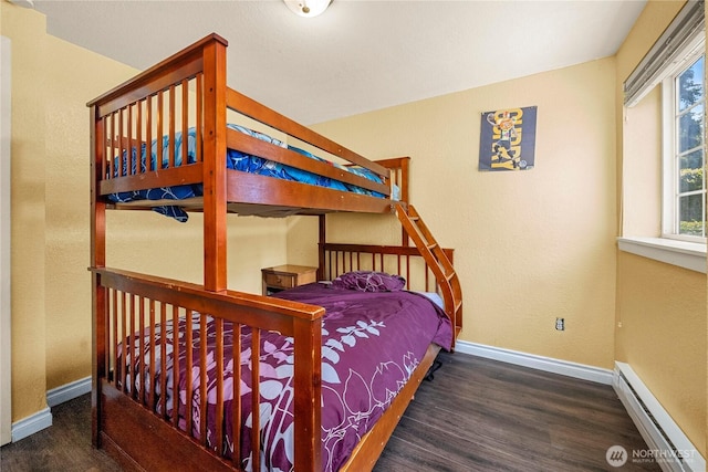 23410 18th Ave S Unit A102, Des Moines, WA 98198 - bedroom featuring a baseboard heating unit, wood finished floors, and baseboards