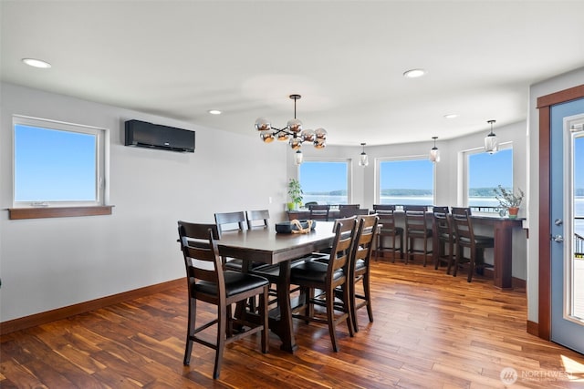 8210 Walnut Rd NE, Olympia, WA 98516 - dining space featuring an AC wall unit, wood-type flooring, a chandelier, baseboards, and recessed lighting