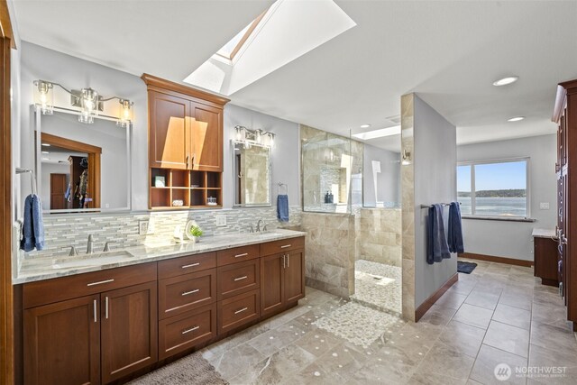 8210 Walnut Rd NE, Olympia, WA 98516 - bathroom featuring a skylight, double vanity, a walk in shower, and tile patterned flooring