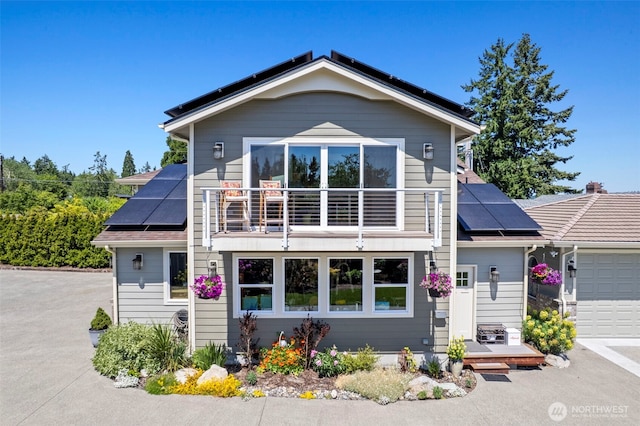 8210 Walnut Rd NE, Olympia, WA 98516 - view of front of property featuring roof mounted solar panels, a balcony, and a garage
