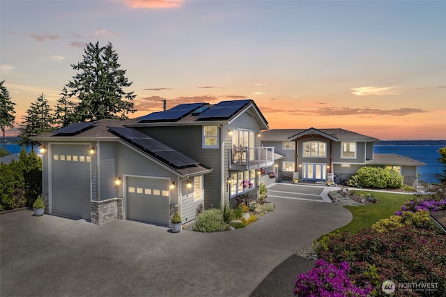 8210 Walnut Rd NE, Olympia, WA 98516 - traditional-style house featuring a balcony, french doors, driveway, solar panels, and stone siding
