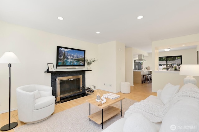 9930 NE 144th Ln Unit 206, Kirkland, WA 98034 - living area featuring wood finished floors, a fireplace with flush hearth, recessed lighting, and baseboards