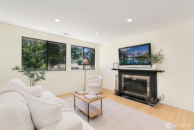 9930 NE 144th Ln Unit 206, Kirkland, WA 98034 - living area featuring plenty of natural light, light wood-style floors, a fireplace with flush hearth, recessed lighting, and baseboards