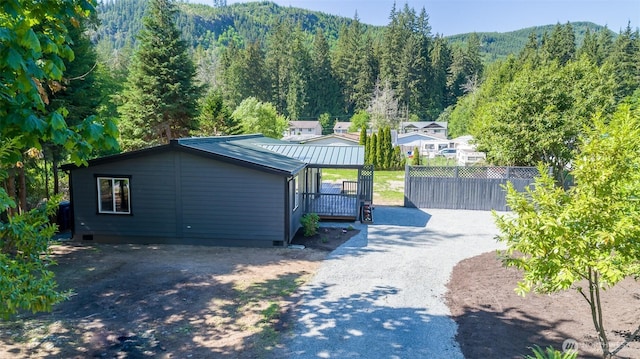 20215 Crystal Springs Dr, Granite Falls, WA 98252 - view of front of property featuring dirt driveway, a wooded view, metal roof, a mountain view, and crawl space