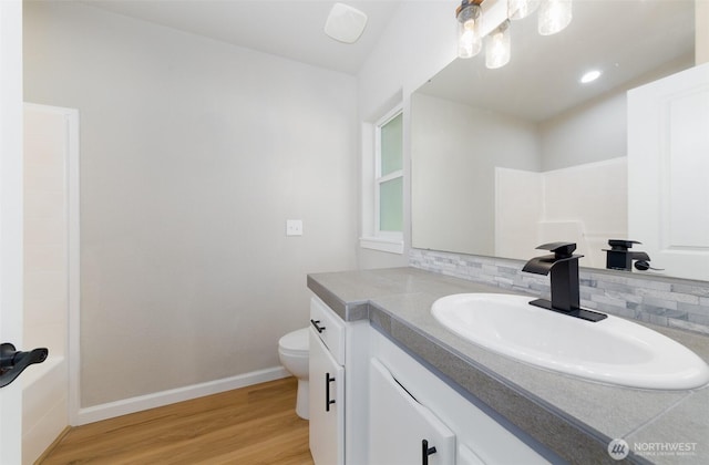 20215 Crystal Springs Dr, Granite Falls, WA 98252 - full bath with backsplash, toilet, vanity, wood finished floors, and baseboards