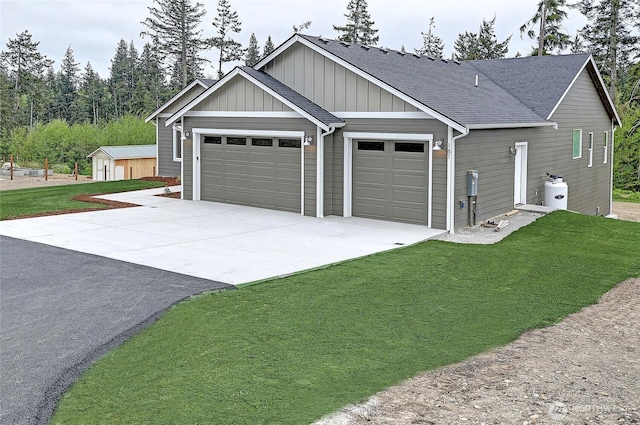 161 N Camano Ridge Rd, Camano Island, WA 98282 - view of front facade with concrete driveway, an attached garage, a front yard, roof with shingles, and board and batten siding