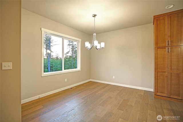 161 N Camano Ridge Rd, Camano Island, WA 98282 - empty room featuring a chandelier, wood finished floors, and baseboards