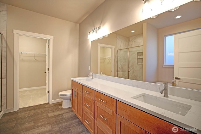 161 N Camano Ridge Rd, Camano Island, WA 98282 - full bath with a stall shower, a walk in closet, wood finished floors, double vanity, and toilet