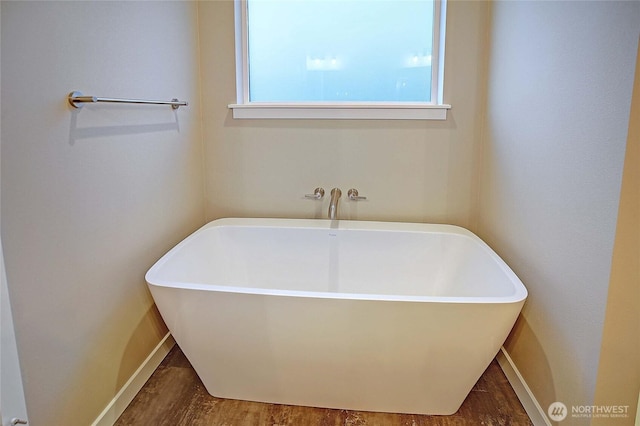 161 N Camano Ridge Rd, Camano Island, WA 98282 - bathroom featuring a freestanding tub, baseboards, and wood finished floors
